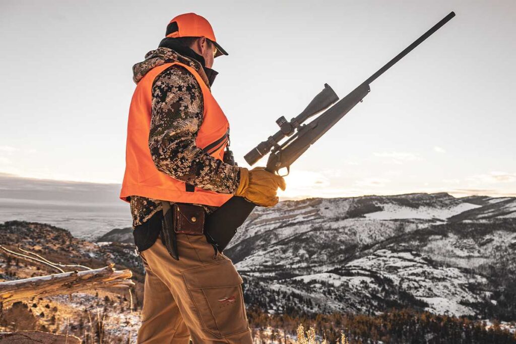 Chasseur avec fusil dans un paysage enneigé.