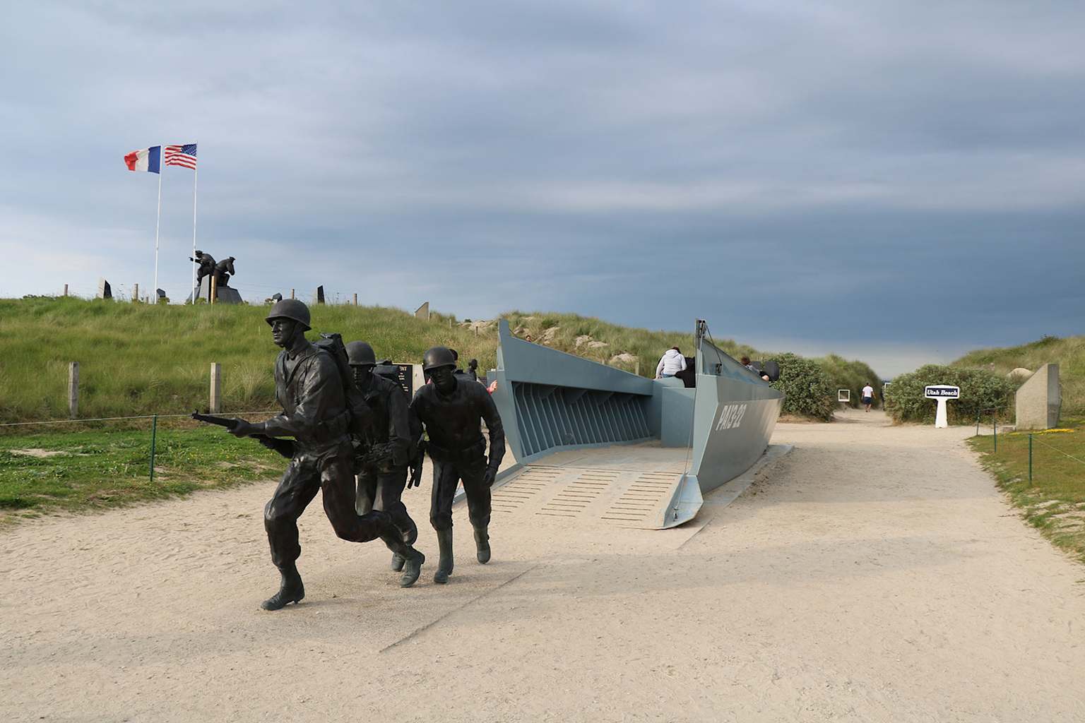 Monument à Utah Beach commémorant le débarquement du jour J avec des soldats en bronze et des drapeaux nationaux